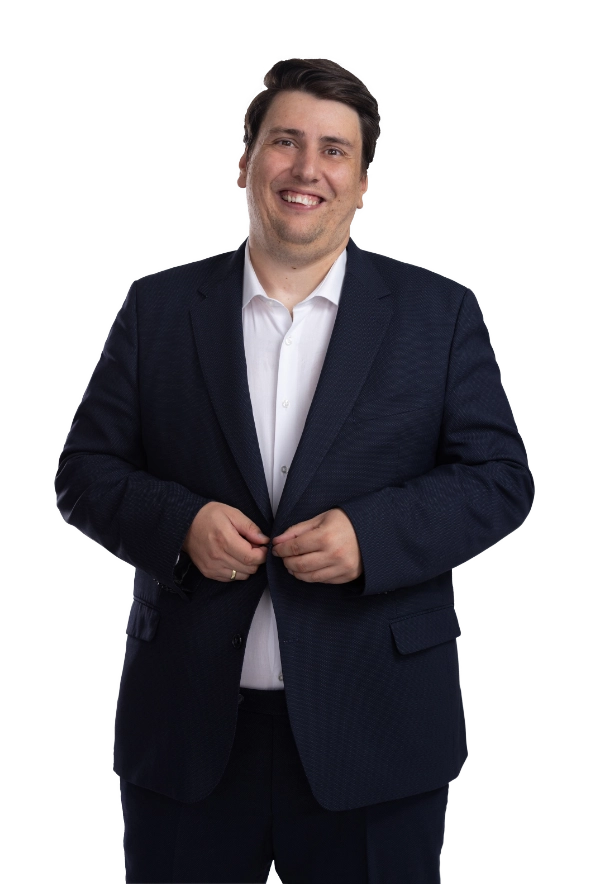 Mentalist Florian Dolar im dunkelblauen Anzug vor grünem Hintergrund