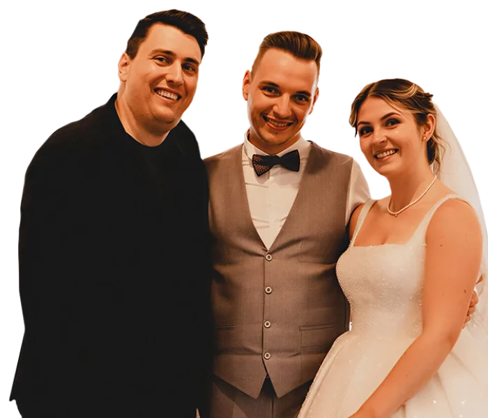 Mentalist Florian Dolar steht lachend neben Braut und Bräutigam auf einer Hochzeit